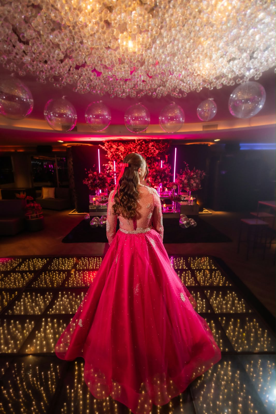 Debutante de vestido rosa vista de costas em sua festa de 15 anos